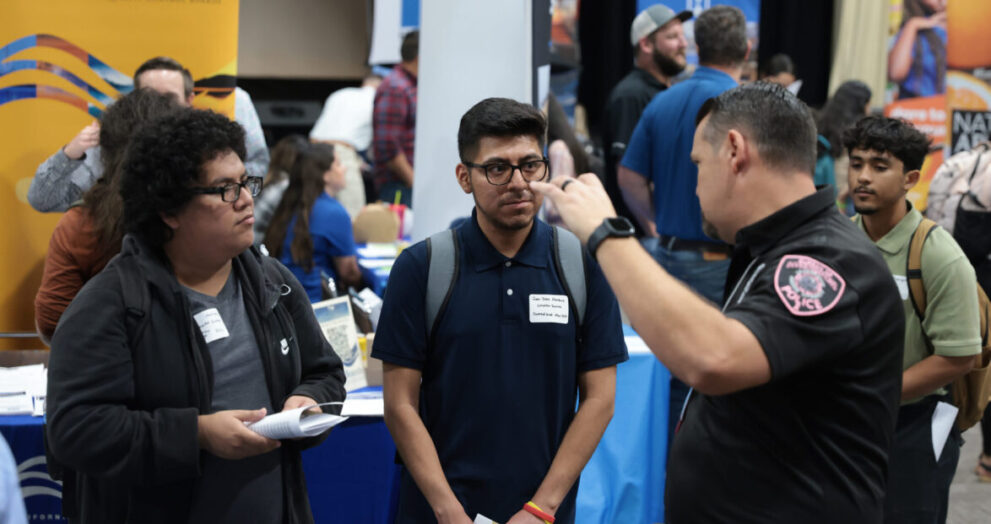 Computer science majors, Martinez and Marquez speak to a police officer representing one of the numerous companies and organizations at the 2023 Fall Career Fair.