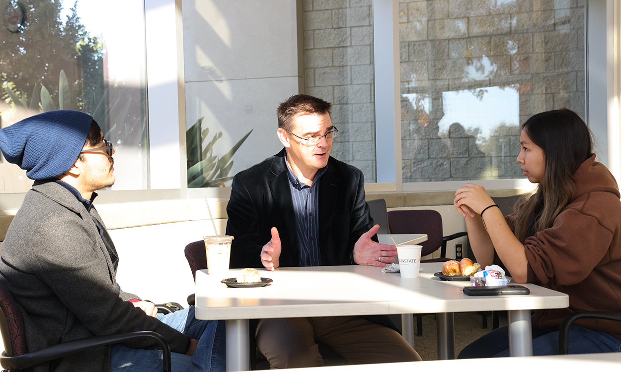 Dr. Jason Bush speaks with students during Donuts with The Dean event.