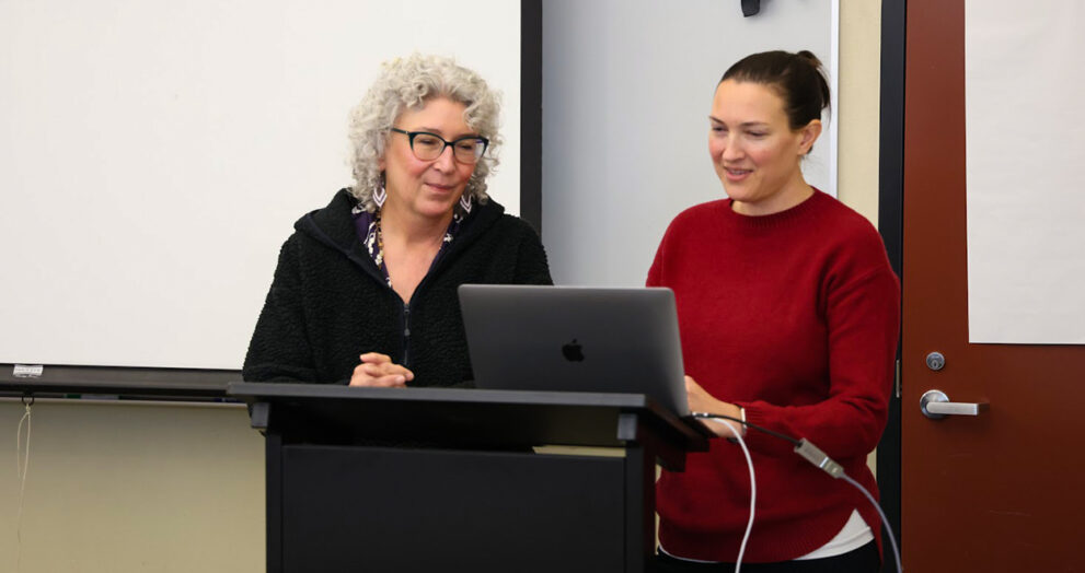 Psychology professors Dr. Constance Jones and Andrea Wiemann consult their notes during the TA bootcamp